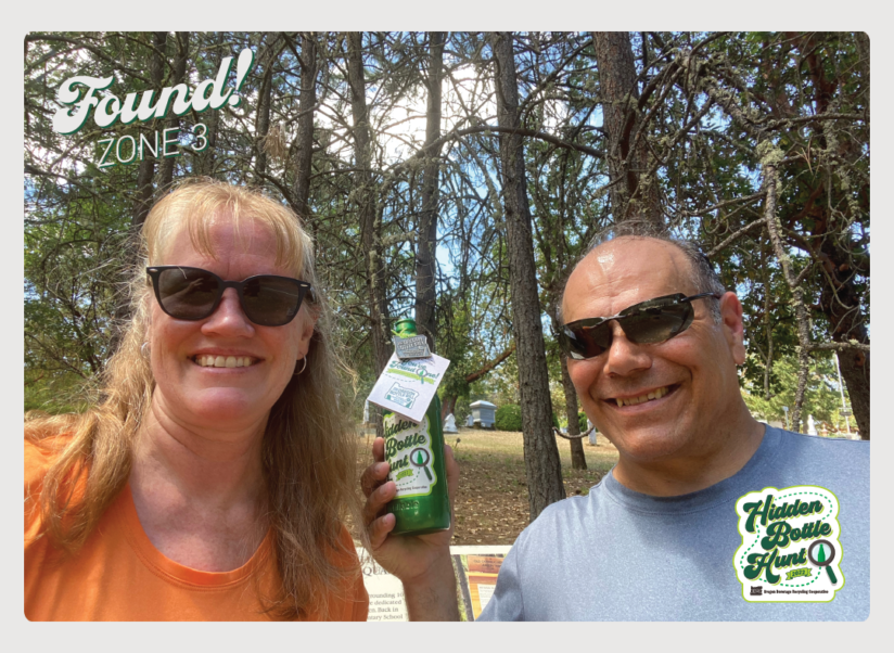 Photo of two adults who found the shiny green commemorative bottle.